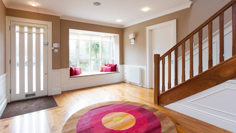 The front door of the house opens into a very large, bright hall with a box bay window and window seat