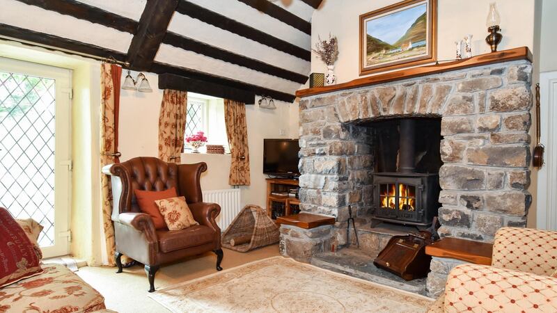 Inside they have decorated to suit the house and so there is a pretty cottage feel, with exposed beams, painted stone walls, and a stone fireplace with woodburning stove as the focal point in the living room.