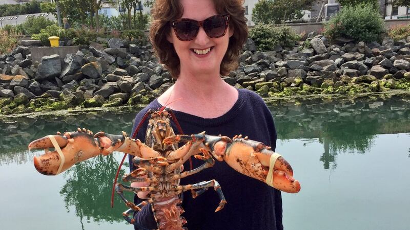 Marie Claire Digby, back on terra firma,  displays a freshly caught lobster. It takes seven years for a lobster to reach maturity. Photograph: Dara Mac Dónaill