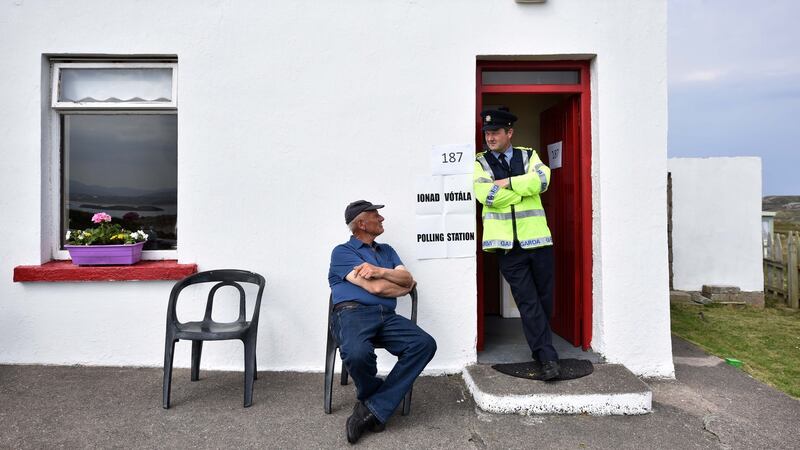 Garda  Pat McElroy chats with resident Jimmy Sweeney whose house acts as the polling station on Gola Island. Photograph:   Charles McQuillan/Getty Images