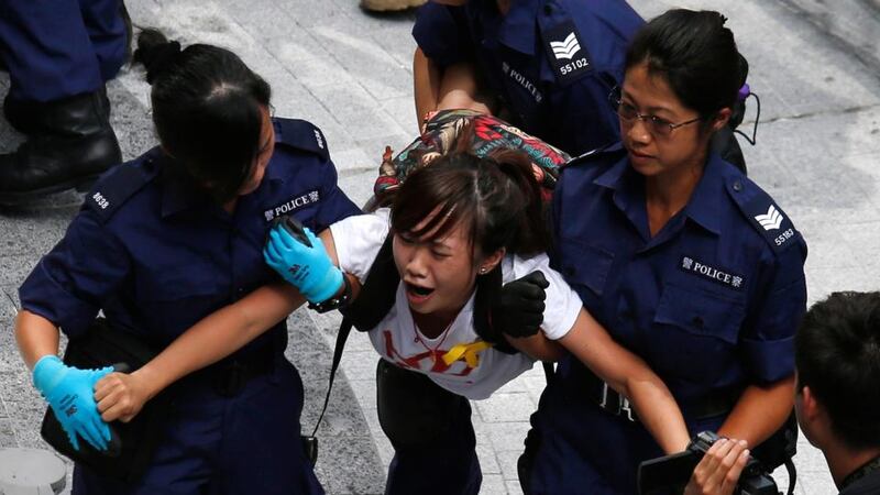 A protester  is dragged away by police after storming in government headquarters in Hong Kong. Photograph: Reuters