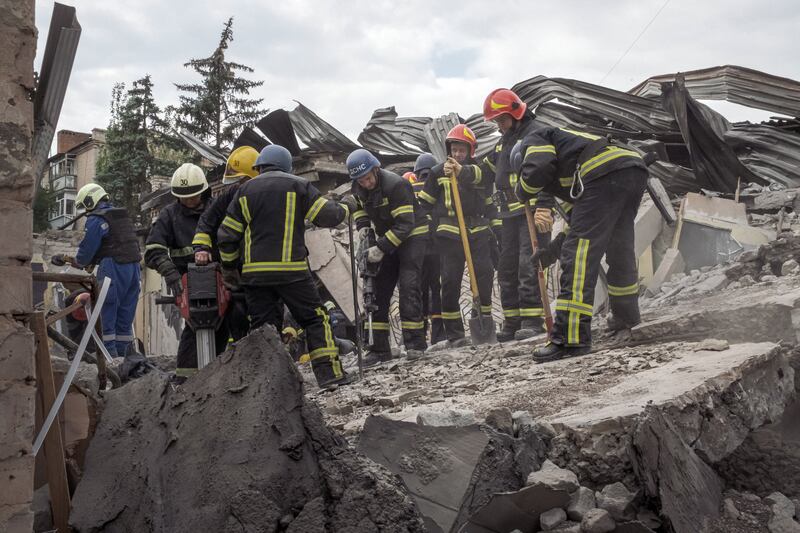 Rescue workers and firefighters use concrete-breaking machinery to try to rescue people after the missile strike on a restaurant in Kramatorsk. Photograph: Mauricio Lima/New York Times
                      