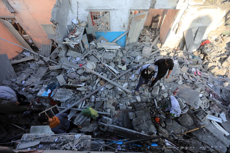 Local men surveying the damage after an Israeli air strike on Khan Younis. Photograph: Yousef Masoud/The New York Times
                      