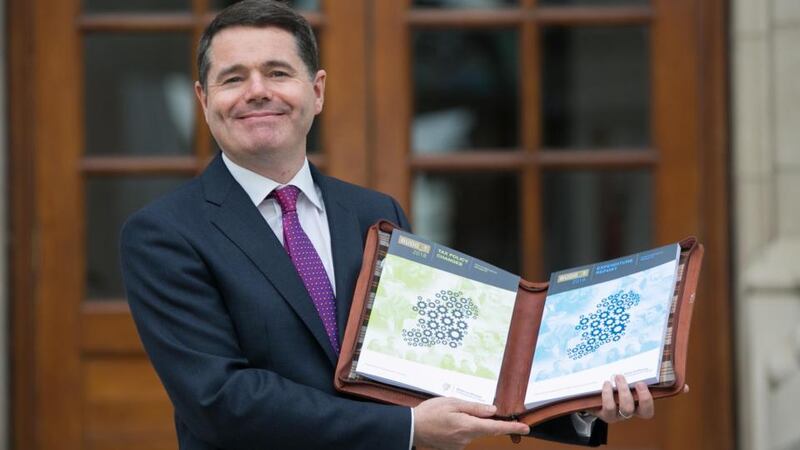 Raining maps and cogs: Minister for Finance Paschal Donohoe shows off Budget 2018. Photograph: Gareth Chaney/Collins