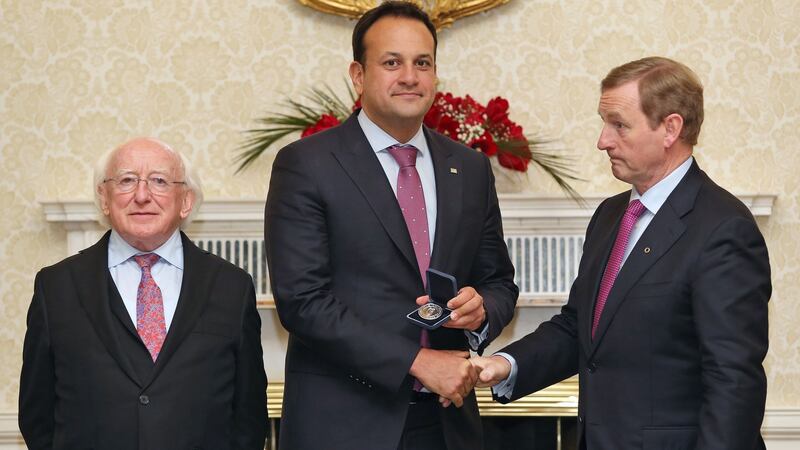 Minister for Social Protection Leo Varadkar with President Michael D Higgins and Taoiseach Enda Kenny after receiving his seal of office at Áras an Uachtarain on Friday night.