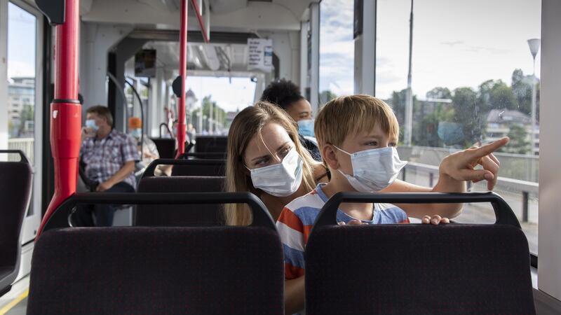A woman and child wearing protective masks sit on a tram in Bern, Switzerland, where authorities have mandated the use of face masks for all people aged 12 and older using any form of public transport. Photograph: Peter Klaunzer/EPA.