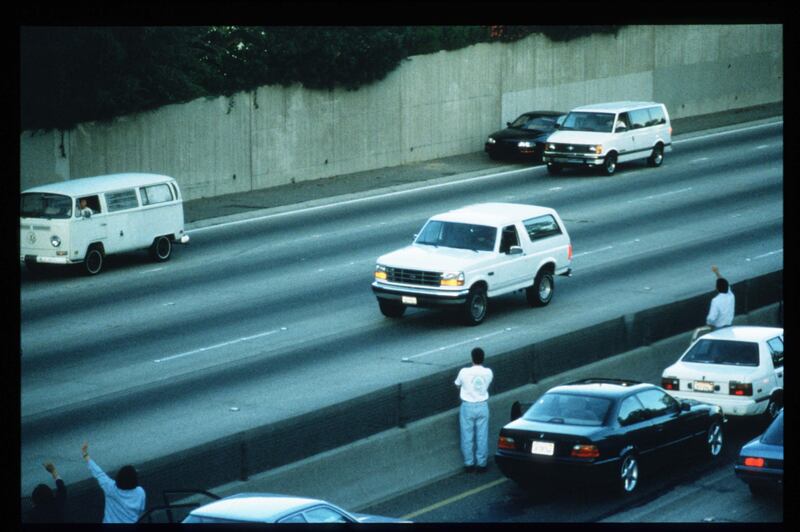 Motorists wave as police cars pursue the Ford Bronco carrying fugitive murder suspect OJ Simpson on a 90-minute slow-speed car chase, June 17th, 1994. Photograph: Jean-Marc Giboux/Liaison