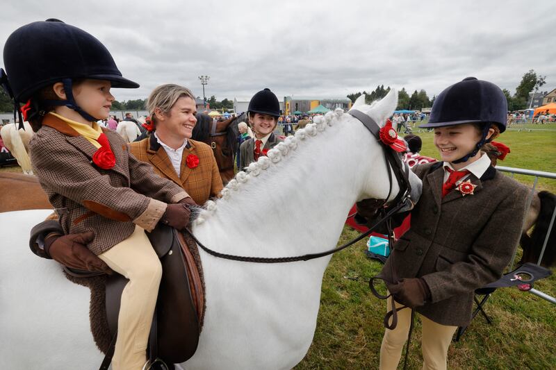Rebecca on Timmy, a Welsh pony, with sisters Hannah and Ava McKenna with Áine Johnson their mum at the 82nd Annual Virginia Show, in Cavan. Photograph: Alan Betson / The Irish Times