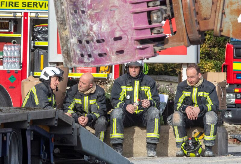 Members of the emergency services rest at the scene of the Creeslough explosion amid rescue efforts. Photograph: Paul Faith/AFP via Getty Images