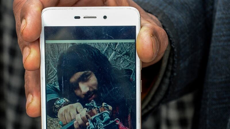 Mohammed Maqbool Bhat shows a picture of his son, Sameer Tiger, who joined Hizbul Mujahedeen, an outlawed Kashmiri separatist group. Soon, his image started popping up on separatist websites. “When we saw that,” Maqbool said, “we said goodbye.” Photograph: Atul Loke/New York Times
