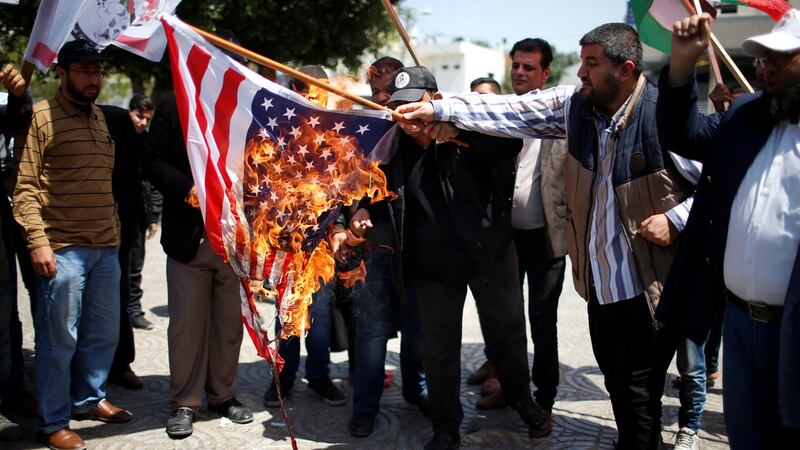 Palestinians burn a US flag during a protest against air strikes in Damascus, in Gaza city April 15, 2018. Photograph:Mohammed Salem/Reuters