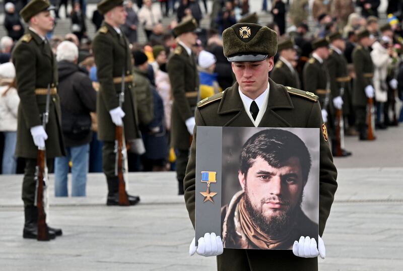 A Ukrainian soldier holds a portrait of Dmytro Kotsiubailo of the 67th brigade during a memorial ceremony at Independence Square in Kyiv in March. Photograph: Sergei Supinsky/AFP via Getty Images