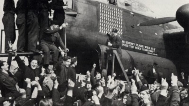 Men of the Royal Air Force in high spirits beside a Lancaster bomber.