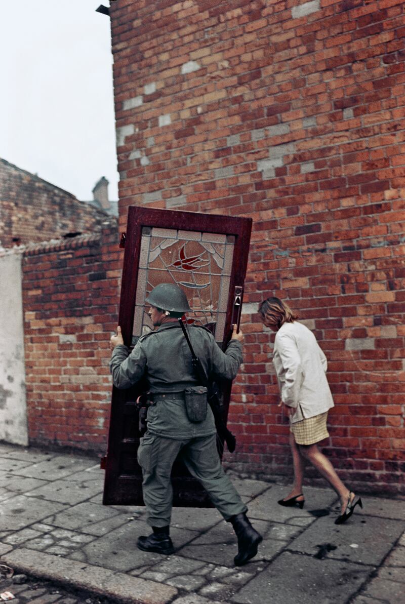 A British soldier carrys a door along Bombay Street, west Belfast in 1969.