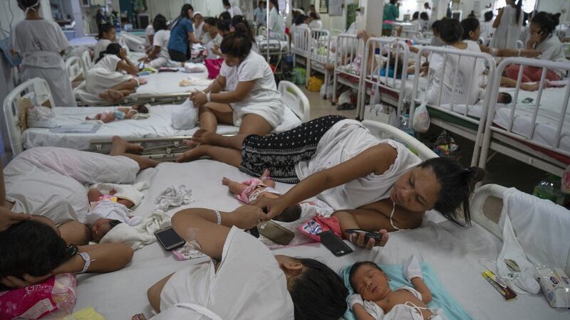 Patients who have just given birth share a bed in Fabella Hospital in Manila on October 21st, 2018. Dr. Jose Fabella Memorial Hospital is considered the busiest maternity hospital with an average of 60 births a day from the poorest patients in Manila and nearby provinces. Photograph: Kimberly dela Cruz