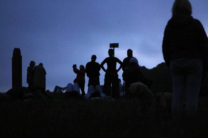 Participants seem like statues as the sun comes up on the Hill of Tara. Photograph: Alan Betson/The Irish Times

