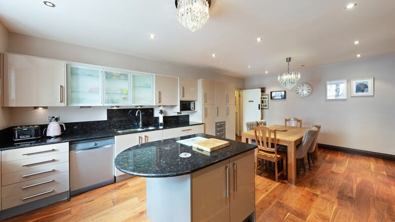 Basement eat-in kitchen fitted with glossy caramel-coloured units