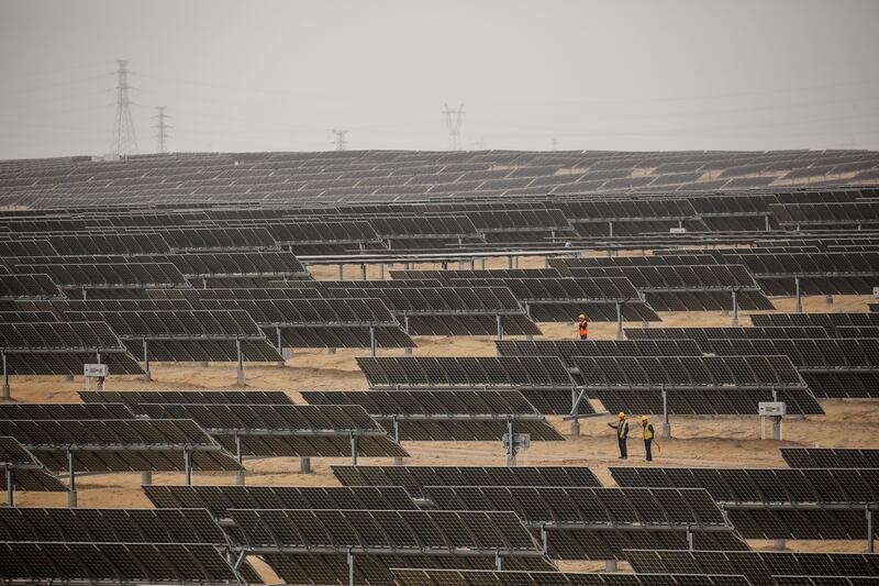 Workers stand near photovoltaic panels at Dalat photovoltaic base in Ordos. Photograph: Wu Hao/EPA-EFE