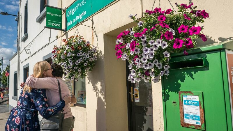 A customer wishes postmistress  Ann Moran (left) well after she locks up on the last day of business at Ballindine post office. Photograph: Keith Heneghan