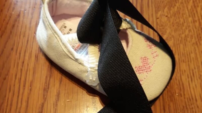 Baby shoe with black mourning ribbon blessed by Pope Francis.