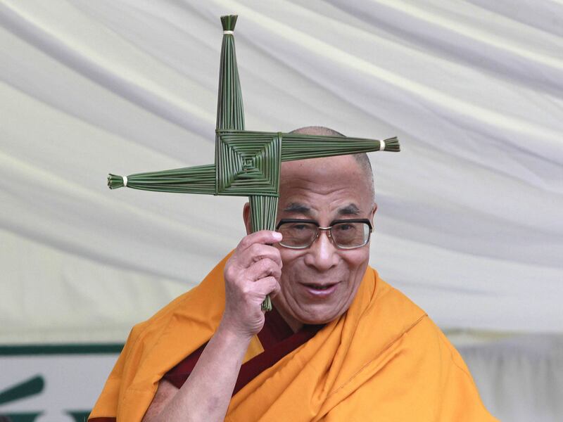 The 14th Dalai Lama holding a St Brigid's cross that was presented to him by school children in Kildare in 2011. Photograph: Brenda Fitzsimons