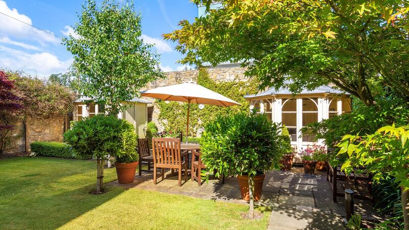 The southwest-facing back garden with and a pair of pretty summer houses for morning coffee or evening meals