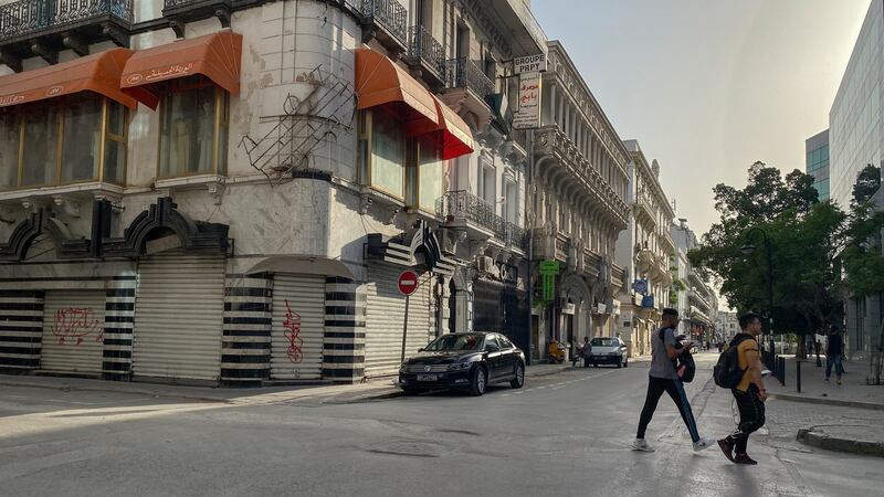 Pedestrians walk the streets of Tunis. Shops were shuttered in the city ahead of a newly extended curfew. Photograph: Sima Diab/The New York Times