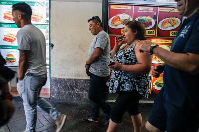 Passers-by in front of a fast food restaurant in downtown Santiago. The medical cost of obesity was 2.4 percent of all health care spending in Chile in 2016 and could rise to 4 percent by 2030.