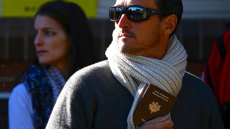 A French national living in Australia holds his passport as he waits to  vote in the presidential poll at a polling booth in Sydney, Australia. Photograph: Reuters/David Gray