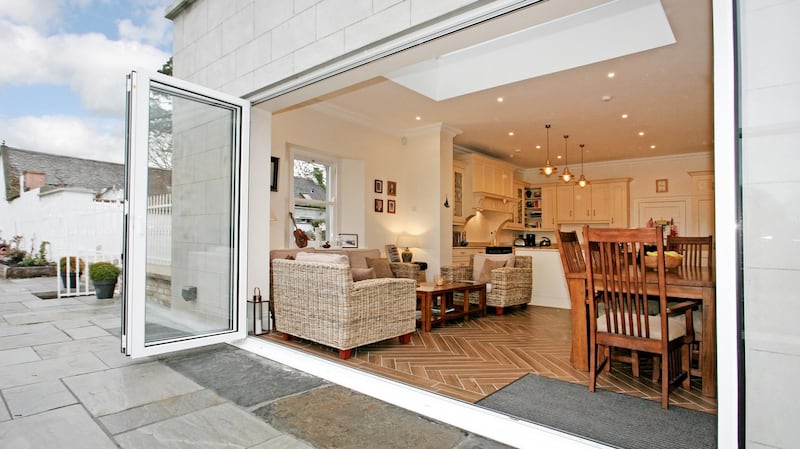 An extension was added to the kitchen,  which   opens it to a limestone patio through concertina doors