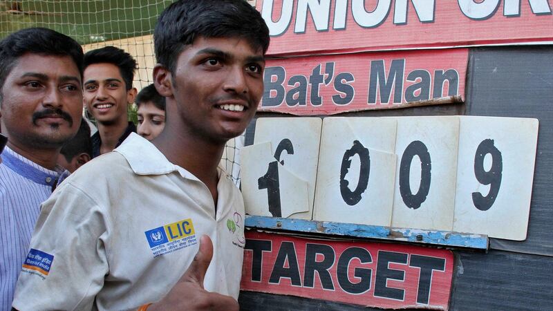 Pranav Dhanawade, 15, poses in front of the scoreboard after scoring 1,009 not out in an inter-school cricket tournament in Mumbai, a new record score in a cricket match. Photograph: Reuters