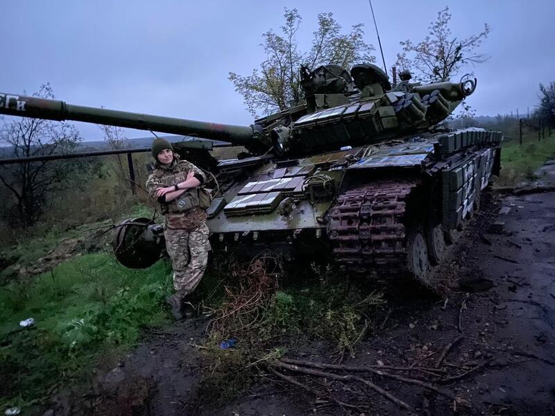 Lt Yulia Mykytenko leans on a disabled Russian tank.