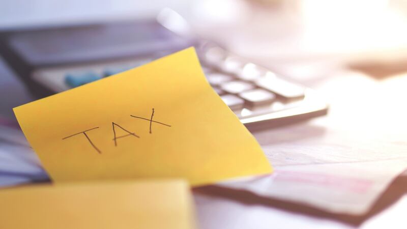 tax time concept with tax word remind note including calculator ,some paper and bills on table,