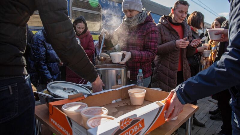 Volunteers provide food aid to Ukrainians fleeing from Kiev to Warsaw, as their train stops at the railway station in Dorohusk, Poland. Photograph: EPA/Wojtek Jargilo