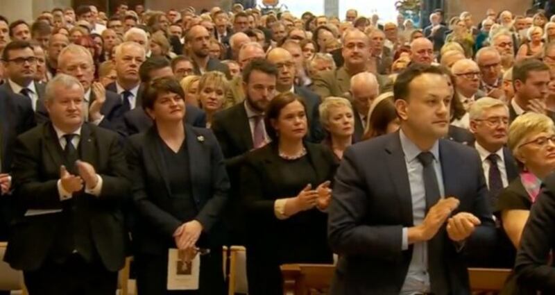 Arlene Foster, Mary Lou McDonald and others applaud during Fr Magill's homily