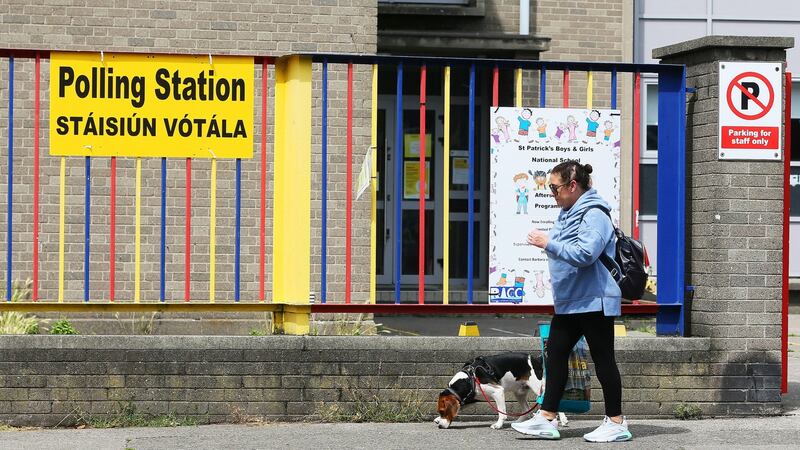A woman walks a dog past a Dublin Bay South polling station at St Patrick’s Girls National School in Ringsend ahead of Thursday’s byelection. Photograph: Brian Lawless/PA Wire.