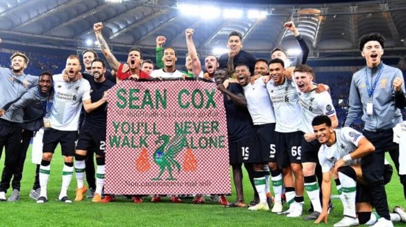 Liverpool players celebrate with a banner supporting   Sean Cox who was attacked  ahead of the first leg match during Champions League semi final. Photograph: Ettore Ferrari/EPA.