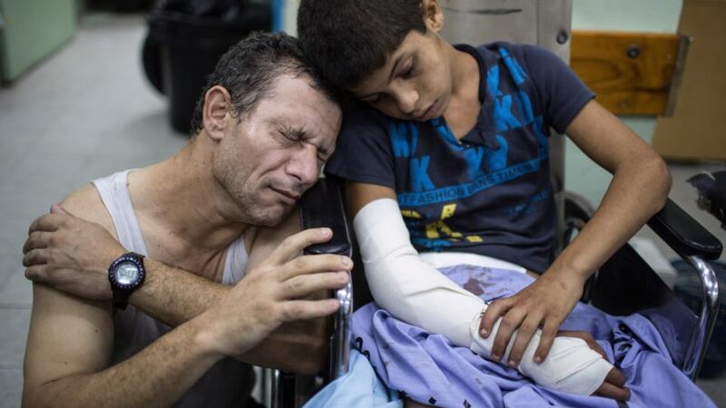 Yasser Assaf leans on the shoulder of his wounded son Abdul Rahman (14) at the Kamal Odwan hospital in Beit Lahiya, in the northern Gaza Strip last night . Many of those injured when Israeli artillery fire reportedly hit a United Nations-run school in Jabaliya -- an attack that Palestinian health officials say killed at least 20. Photograph: Wissam Nassar/The New York Times