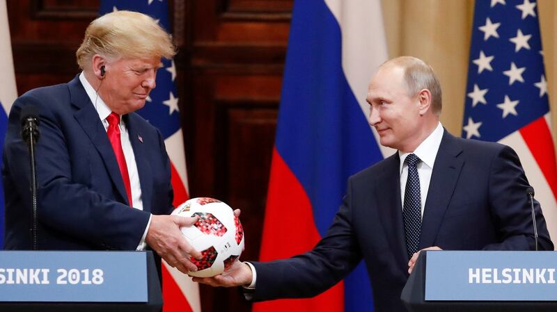 US president Donald Trump receives a football from Russian president Vladimir Putin at a joint news conference after their meeting in Helsinki, Finland. Photograph:  Grigory Dukor/Reuters