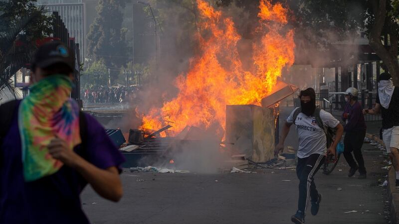 Demonstrators clash with riot police  in Santiago, Chile. Photograph: Claudio Reyes/AFP/Getty
