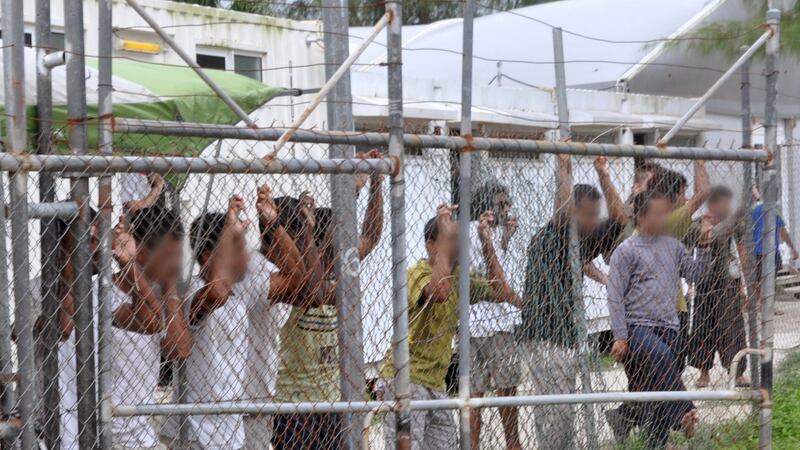 Asylum seekers behind a fence at the Manus Island detention centre, Papua New Guinea, in a photograph taken in March 2014. Australian immigration minister Peter Dutton said none of the asylum seekers in the camp would be settled in Australia when it closed. Photograph: Eoin Blackwell/AAP/Reuters