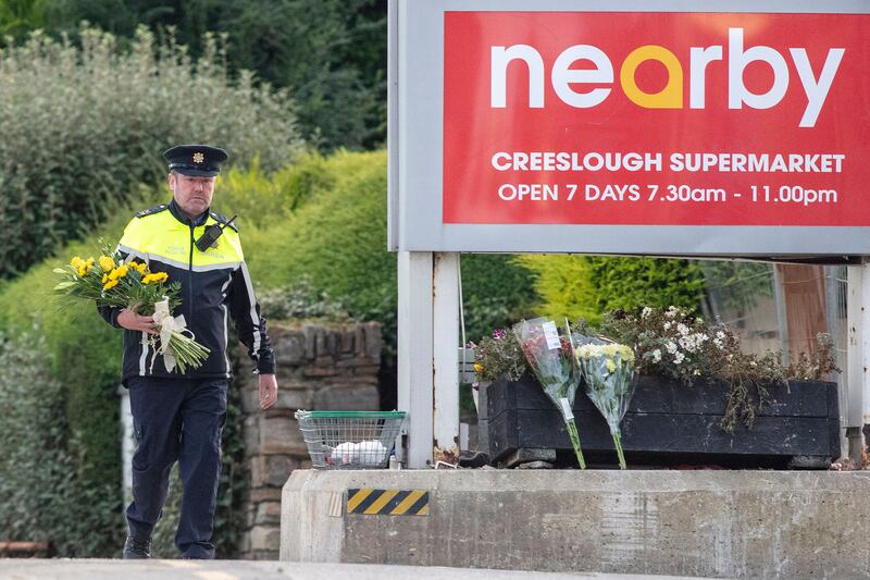A garda lays flowers at the scene of an explosion at the petrol station in Creeslough last month. Photograph: Paul Faith/AFP via Getty Images