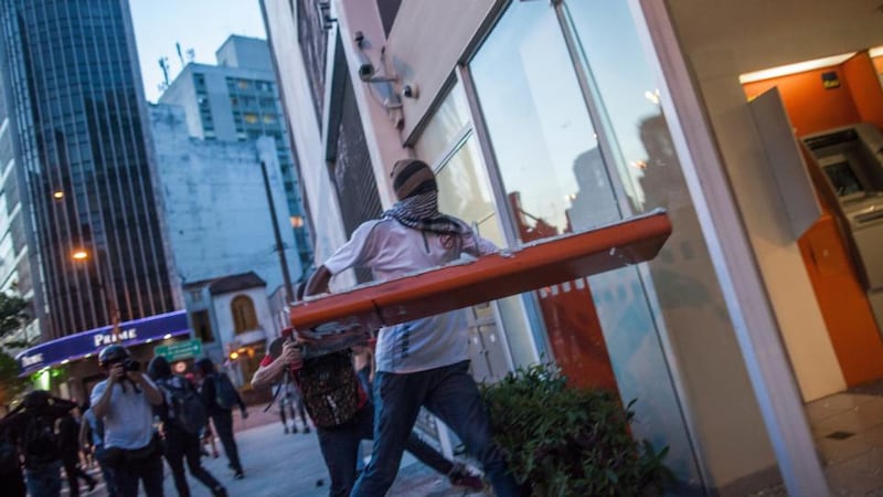 Protesters break the glass windows of an agency bank during demonstrations against the staging of the upcoming 2014 World Cup. Photograph: Victor Moriyama/Getty Images