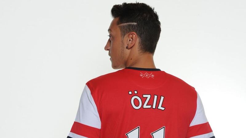 Mesut Ozil poses in his new Arsenal shirt in Munich yesterday. Germany coach  Joachim Löw has criticised Real Madrid for selling the midfield play-maker. Photograph:  Stuart MacFarlane/Getty Images.