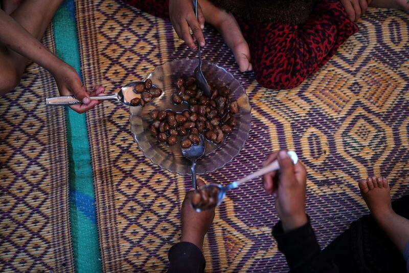 Children of the Abdelaal family share a plate of beans. Photograph: Abdel Kareem Hana/AP