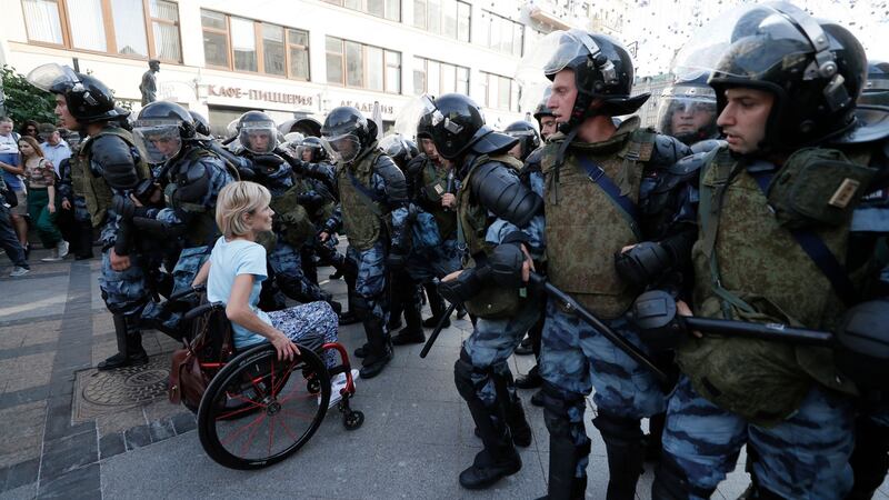 A woman in a wheelchair goes through the police line during a protest in the centre of Moscow. Photograph: Yuri Kochetkov/EPA