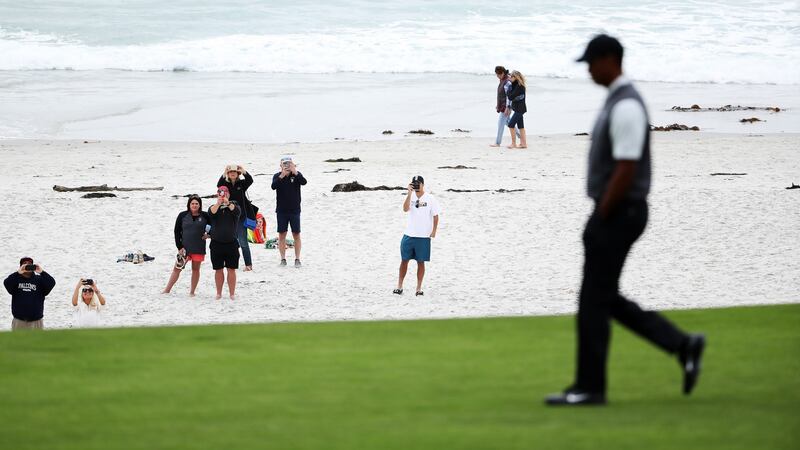 Spectators on the beach watch Tiger Woods walk down the 10th hole. Photo: Christian Petersen/Getty Images