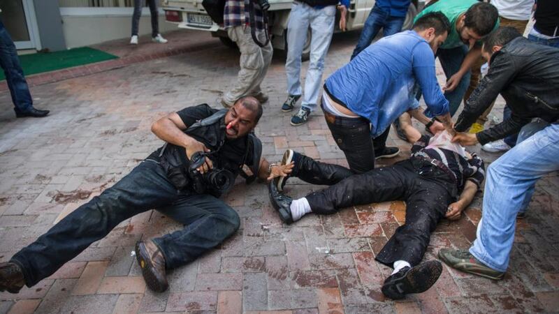 Fellow demonstrators try to treat a man who was injured when riot police used rubber bullets, tear gas and water cannons against a crowd demonstrating over the fatal mine fire in Soma, Turkey. Photograph: Uriel Sinai/The New York Times.