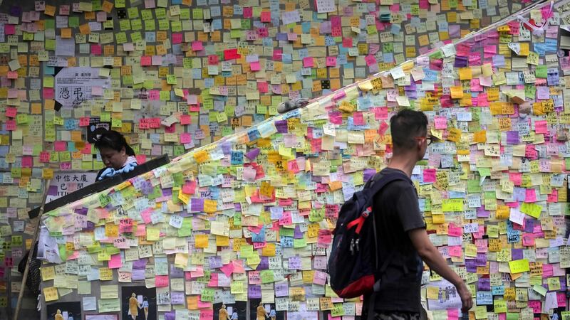 People walk past notes left by protesters on the walls of the government headquarters in Hong Kong on Tuesday. Photograph: Vivek Prakash/ AFP/Getty Images