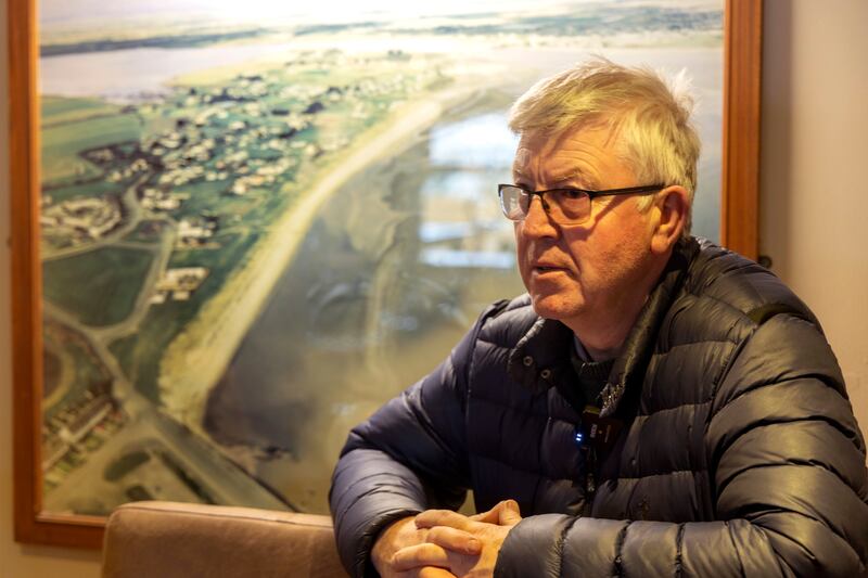 Michael Moynihan runs the The Brook Pub, which sits near the shore in Portrane in north Co Dublin. Behind him is an aerial photo from 1998 that shows how the beach used to be before the effects of coastal erosion washed it away. Photograph: Chris Maddaloni
